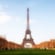 The Eiffel Tower surrounded by a long lawn and trees